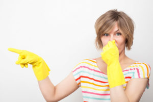 image of woman noticing bad odor in garbage disposal