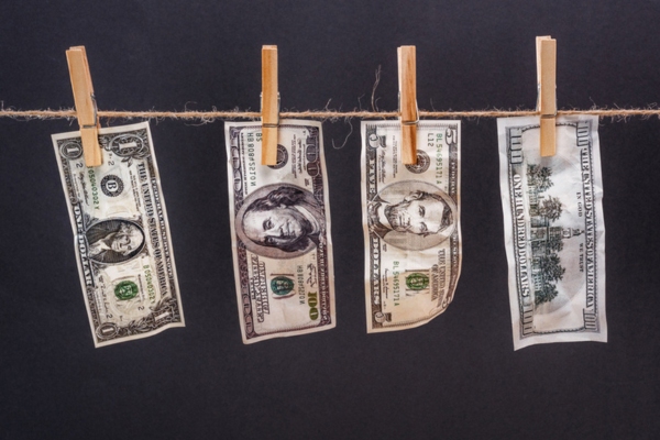 Dollar banknotes hanging on thin rope depicting costs