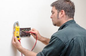 HVAC technician working on thermostat