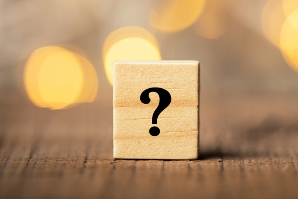 question mark on a wooden letter chip depicting FAQs about single zone vs multi zone ductless system