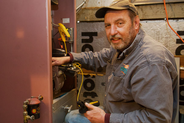 image of an hvac contractor performing furnace maintenance