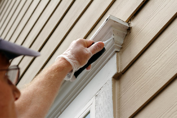 image of homeowner sealing air drafts