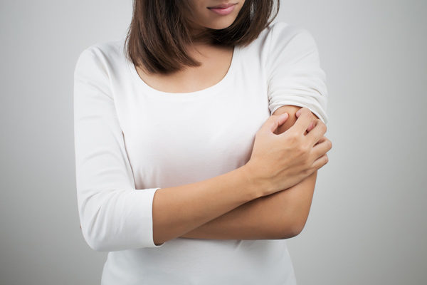 image of woman feeling itchy due to dry indoor air