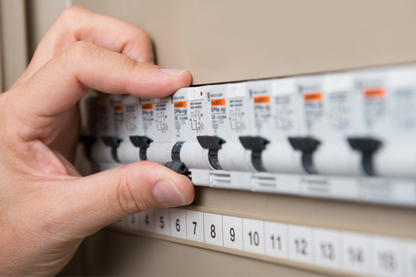 image of homeowner at circuit breaker box after ac stopped working