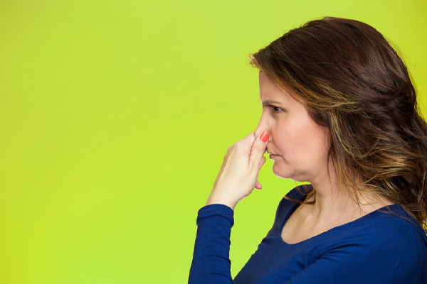 woman plugging nose due to smelly air conditioner