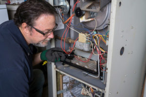 image of an hvac contractor performing annual furnace maintenance