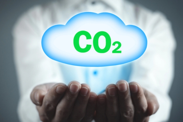 man holding CO2 symbol with cloud depicting carbon emission