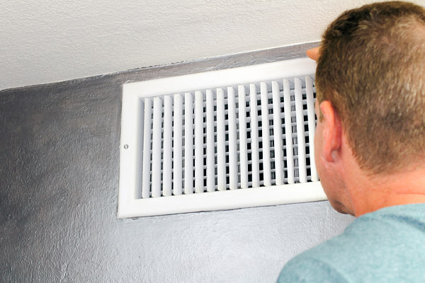 Man Looking in an Air Vent