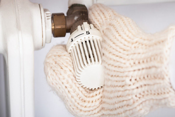 Hand Wearing Mitten Turning Knob Of Radiator Due To Running Out Of Heating Oil