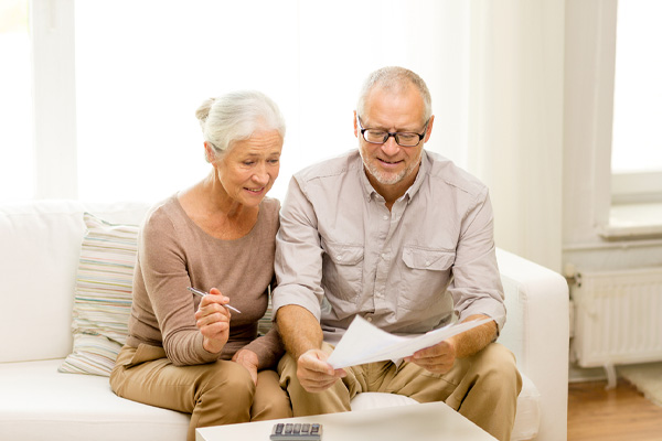 Smiling couple calculating energy savings with a new efficient home heating system