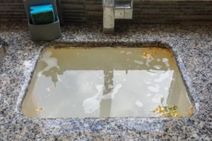 Overflowing kitchen sink due to broken garbage disposal