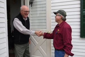 hvac contractor in hardhat discussing heating and ac installation plans with homeowner