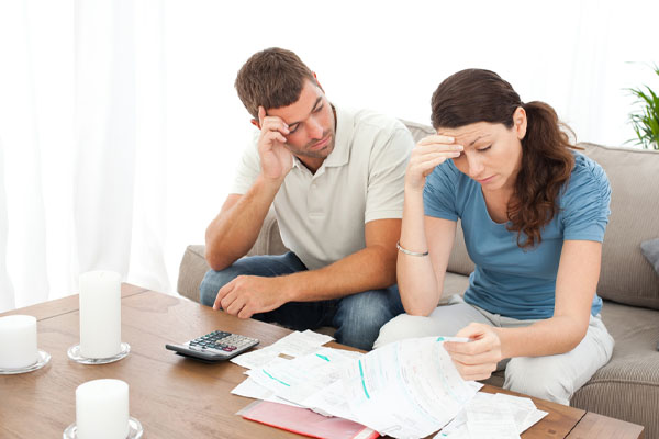 couple looking at energy costs and high energy cost of heating and air conditioning