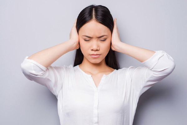 image of homeowner covering ears due to air conditioner noises