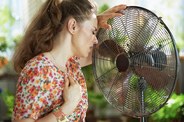 image of homeowner experiencing heat exhaustion due to a broken air conditioning system