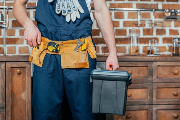 Mid section of a professional with tool belt holding toolbox depicting professional Generator Maintenance