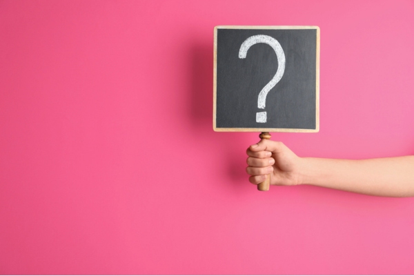 question mark sign held in front of pink wall depicting questions about Standby Generator Maintenance