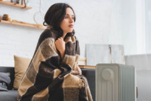 image of homeowner using a space heater for heat during boiler malfunction