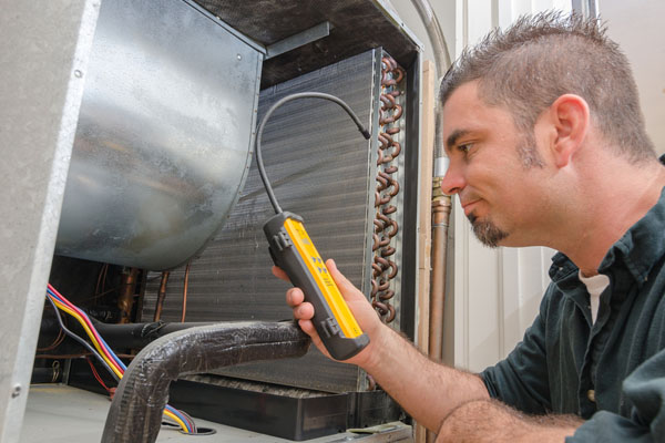 image of an hvac contractor using manometer to check ac refrigerant levels