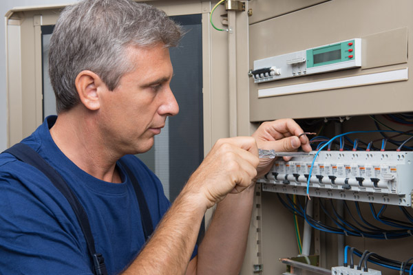 electrician repairing circuit breaker box due to air conditioner tripping circuit breaker