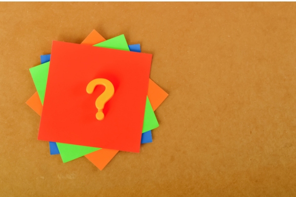 question mark on a stack of colored papers depicting FAQs about outside ac unit tripping breaker