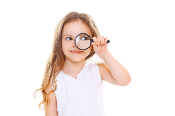 young girl holding a magnifying glass on her left eye depicting indicators of too much AC refrigerant