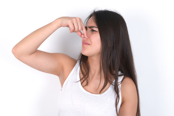 image of a homeowner plugging nose due to hvac emitting bad smell