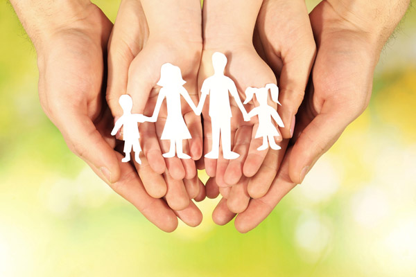 image of paper family in hands depicting home heating safety