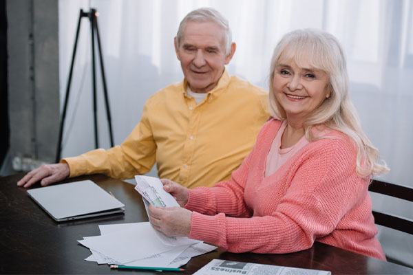 happy senior couple saving money on energy costs