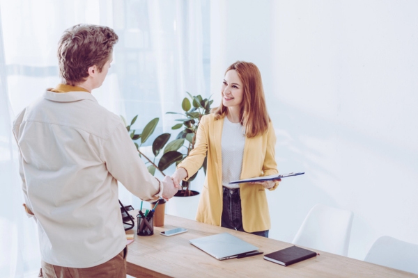 woman shaking hands and explaining HVAC service agreement