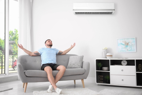 man sitting on the couch enjoying the cool air from ductless AC