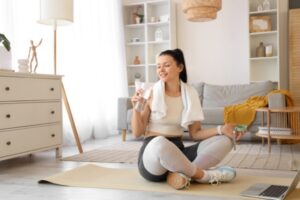 woman hydrating after working out inside the house with comfortable air conditioning