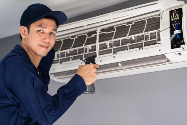 HVAC technician cleaning ductless air conditioner