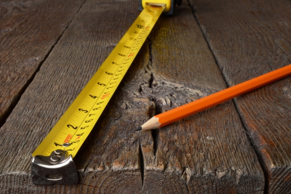 close up of tape measure and pencil depicting proper generator size