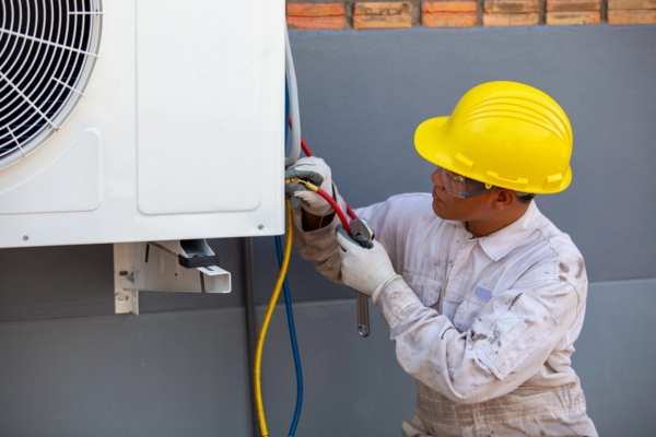 professional HVAC technician installing new air conditioner