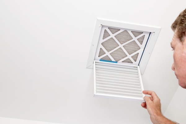 man inspecting HVAC vent