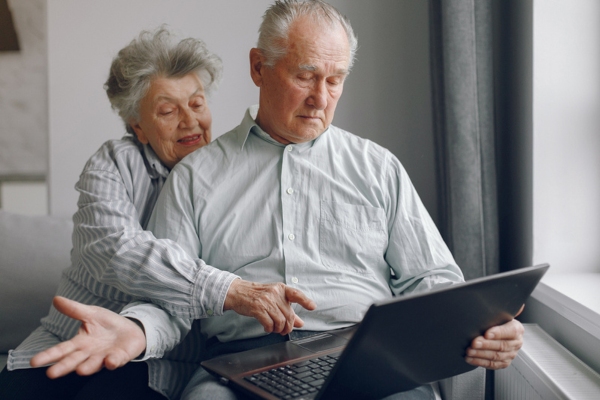 senior couple researching using a laptop depicting selecting the best standby generator