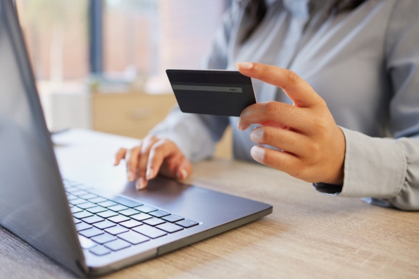 woman encoding card details on a laptop depicting automatic oil delivery sign-up