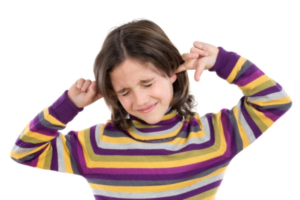 young girl covering her ears with her fingers due to furnace noise