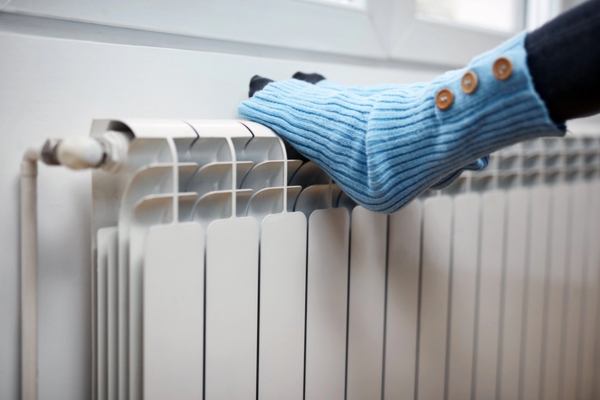 feet keeping warm on top of a home heating oil radiator