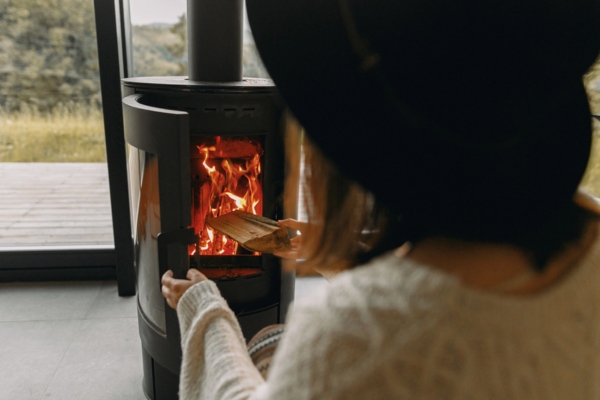 woman putting firewood inside a fireplace