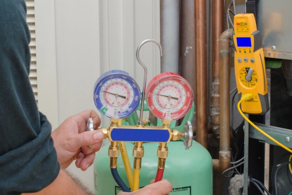 HVAC technician refilling air conditioner refrigerant