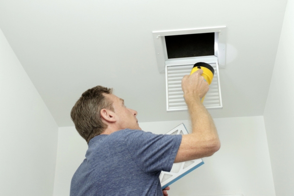homeowner examining HVAC air duct system