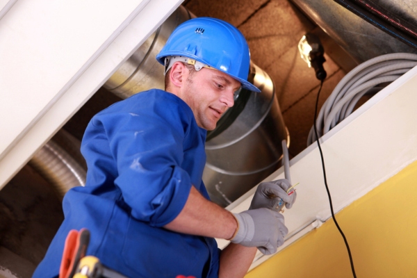 professional HVAC technician tending to a duct system