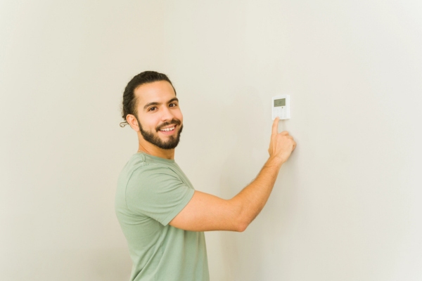 homeowner setting home thermostat
