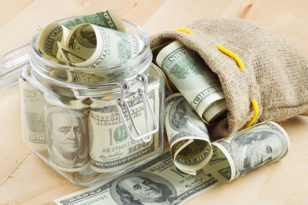 money on jar and jute bag depicting savings