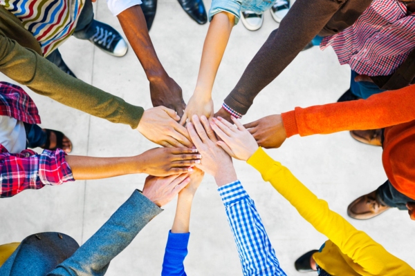 top view of diverse people from the community doing a teamwork handshake gesture