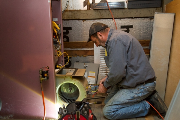 Skylands Energy Service HVAC technician tending to a furnace
